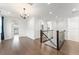 Bright upstairs landing with hardwood flooring, dark railing, and multiple doorways at 8106 Mabury Ln, Orlando, FL 32832