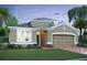 Charming single-story home with a well-manicured lawn, two-car garage, and neutral-colored stucco facade at 813 River Stone Trl, Sanford, FL 32771
