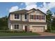 Charming two-story home featuring a two-car garage, neutral siding, shutters, and well-maintained landscaping at 825 River Stone Trl, Sanford, FL 32771