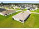 Expansive aerial view of a community showcasing well-maintained homes with lush green lawns and mature trees in the background at 9020 Se 42Nd Ct, Ocala, FL 34480