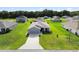 Aerial view of home with blue siding, green lawn, two car garage, and a long driveway at 9020 Se 42Nd Ct, Ocala, FL 34480