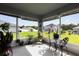 View of screened lanai furnished with a table and chairs, and filled with plants with a backyard view at 9020 Se 42Nd Ct, Ocala, FL 34480