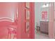 Hallway view into a bright bathroom, and a sitting area featuring pink walls and chairs at 10293 Ebb Tide Ln, Orlando, FL 32821