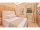 Cozy bedroom with a decorative wood accent wall, and two large windows with neutral curtains at 10293 Ebb Tide Ln, Orlando, FL 32821
