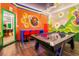 Vibrant game room with brick wall, Mario themed decor, air hockey table, and colorful gaming chairs at 10293 Ebb Tide Ln, Orlando, FL 32821