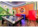Spacious game room with air hockey, brick wall, Mario themed decor, and colorful overhead lighting fixtures at 10293 Ebb Tide Ln, Orlando, FL 32821