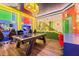Fun game room with air hockey table, TVs, Mario themed wall art, and gaming chairs for entertainment at 10293 Ebb Tide Ln, Orlando, FL 32821