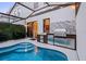 Backyard pool featuring an outdoor kitchen with stainless steel grill, cabinets, and sink under a protective enclosure at 10293 Ebb Tide Ln, Orlando, FL 32821