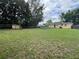 Large backyard with ample green space, a shed, a pool, and mature trees, perfect for outdoor activities at 108 Country Club Cir, Sanford, FL 32771