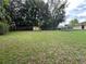 Large, grassy backyard featuring mature trees, shed and volleyball net at 108 Country Club Cir, Sanford, FL 32771