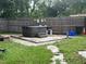 Private backyard featuring a hot tub, wood fence, a well-maintained lawn and additional outdoor amenities at 108 Country Club Cir, Sanford, FL 32771