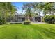 Expansive backyard with lush lawn, screened pool, mature trees, and patio at 11425 Claymont Cir, Windermere, FL 34786