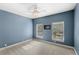 Blue bedroom with ceiling fan, carpeted floor and bright windows at 11425 Claymont Cir, Windermere, FL 34786
