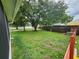 Spacious backyard featuring a large grassy area, mature trees, and a privacy fence, offering ample space for outdoor activities at 11500 Benbow Ct, Orlando, FL 32837