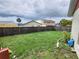 Large fenced-in backyard with green grass, providing a private outdoor space for recreation and relaxation with some toys scattered at 11500 Benbow Ct, Orlando, FL 32837