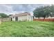 View of the home's exterior and fenced-in backyard, complete with a sliding glass door and a well-maintained lawn at 11500 Benbow Ct, Orlando, FL 32837