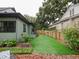 Backyard with artificial turf and outdoor seating, surrounded by lush landscaping and a wooden fence at 1227 Golden Ln, Orlando, FL 32804