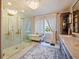 Elegant bathroom featuring a marble shower, soaking tub, vanity, and a chandelier at 1227 Golden Ln, Orlando, FL 32804