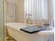 Clawfoot tub with gold faucet fixtures in a bright bathroom with large window and gold towel rack at 1227 Golden Ln, Orlando, FL 32804