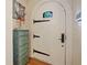 Elegant entryway featuring an arched door, antique cabinet, and charming decor at 1227 Golden Ln, Orlando, FL 32804