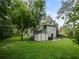 A charming house with mature trees, lush landscaping, and a storage shed on a well-manicured lawn at 1227 Golden Ln, Orlando, FL 32804