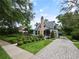 Charming home featuring a brick chimney, lush landscaping, and a paved driveway at 1227 Golden Ln, Orlando, FL 32804