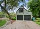 Two-car garage with a charming exterior, complemented by lush landscaping and a brick pathway at 1227 Golden Ln, Orlando, FL 32804