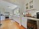 Open kitchen with stainless steel appliances, white cabinetry, wet bar and hardwood floors at 1227 Golden Ln, Orlando, FL 32804
