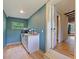 Modern kitchenette with a bright window, white cabinets, and adjacent hardwood flooring at 1227 Golden Ln, Orlando, FL 32804