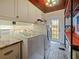 Laundry room with a stacked washer and dryer, custom cabinets, and brick floors at 1227 Golden Ln, Orlando, FL 32804