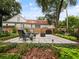 Relaxing backyard patio with outdoor seating, a fire pit, and mature trees in a serene setting at 1227 Golden Ln, Orlando, FL 32804