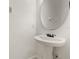 Simple powder room with pedestal sink, oval mirror, and neutral walls at 1277 Blessing St, Maitland, FL 32751