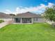 Beautiful backyard featuring a well-maintained lawn, covered patio with outdoor dining area and barbecue grill at 1540 Orange Valley Rdg, Ocoee, FL 34761