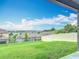 View from covered patio of the green backyard with fence and neighborhood lake view at 1540 Orange Valley Rdg, Ocoee, FL 34761