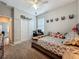A furnished bedroom, featuring carpet flooring, a ceiling fan, natural light, and a bed adorned with stuffed animals at 1540 Orange Valley Rdg, Ocoee, FL 34761