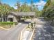 Stone entrance with gate to the community, featuring a wooded landscape at 1540 Orange Valley Rdg, Ocoee, FL 34761