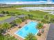 A pool with surrounding palm trees and lounge chairs near a lake in the community at 1540 Orange Valley Rdg, Ocoee, FL 34761