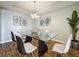Modern dining room features glass table, stylish chairs, and tray ceiling detail at 1540 Orange Valley Rdg, Ocoee, FL 34761