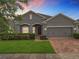 Charming single-story home featuring a well-manicured lawn and a brick-paved driveway at 1540 Orange Valley Rdg, Ocoee, FL 34761