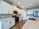 A modern kitchen with stainless steel appliances, white cabinets, quartz countertops, and beautiful backsplash at 1540 Orange Valley Rdg, Ocoee, FL 34761