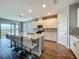 Bright, open kitchen features a large island, quartz countertops, stainless appliances, and wood-look tile flooring at 1540 Orange Valley Rdg, Ocoee, FL 34761