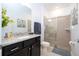 Well-lit bathroom with a modern vanity, granite countertop, and a glass-enclosed shower at 16061 Blue Wave Way, Clermont, FL 34714