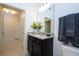 Bright bathroom featuring a dark vanity with granite countertop and a large mirror at 16061 Blue Wave Way, Clermont, FL 34714