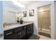 Beautiful bathroom featuring a double vanity with granite countertops, decorative flowers, and walk-in shower at 16061 Blue Wave Way, Clermont, FL 34714