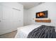 This bedroom features modern minimalist design with a TV above a stylish wood shelf at 16061 Blue Wave Way, Clermont, FL 34714