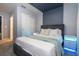 Bedroom with custom blue accent wall, plush gray bed frame, and illuminated nightstands at 16061 Blue Wave Way, Clermont, FL 34714