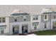 Up close view of townhomes showcasing white and gray tones, covered entryway, and meticulous landscaping at 16061 Blue Wave Way, Clermont, FL 34714