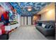 Spacious game room featuring vibrant Mario-themed decor, comfortable seating, and large screen TV at 16061 Blue Wave Way, Clermont, FL 34714