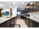 A spacious kitchen features granite countertops, stainless steel appliances, and modern dark cabinetry at 16061 Blue Wave Way, Clermont, FL 34714