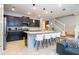 This open kitchen offers modern cabinets, stainless appliances, and a stylish island with barstool seating at 16061 Blue Wave Way, Clermont, FL 34714